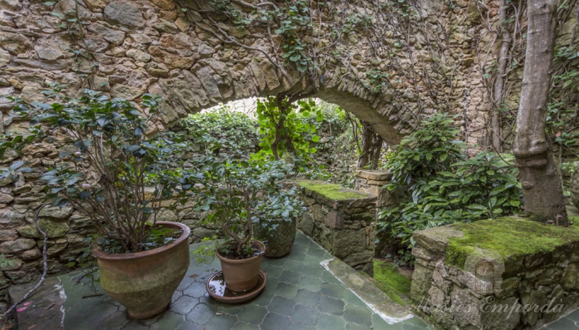 Detalle de la planta baja de la masía con el patio interior con arco de medio punto de piedra