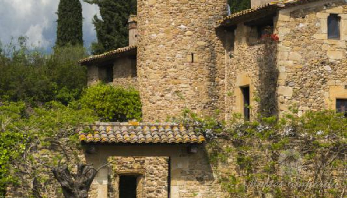 Detalle de la entrada de la masía con torre circular de defensa que la preside 