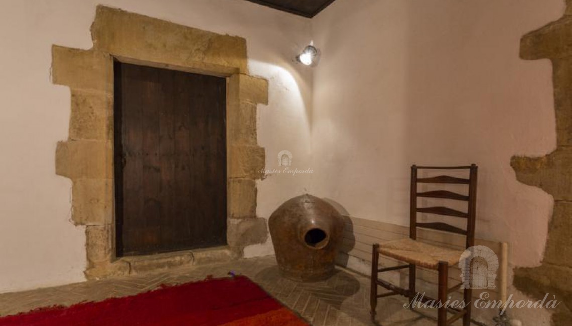  Detalle del hall de entrada a la masía con entrada a la bodega con dintel pilares en piedra trabajada