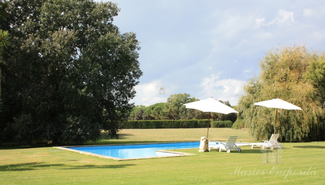 Vistas del conjunto de la piscina y del jardín de esta magnifica casa de campo