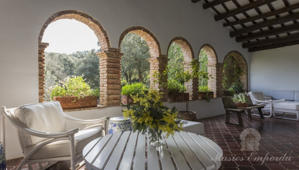 Terraza cubierta del salón principal de la masía con vistas únicas de la comarca