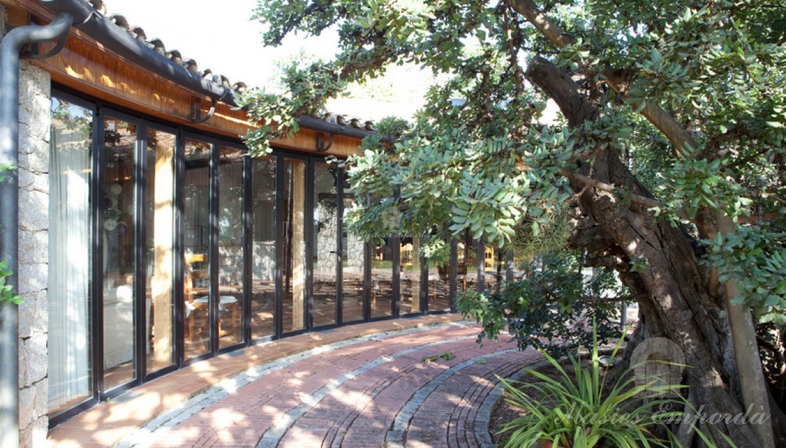 Vista lateral de la entrada a la casa de invitados de la propiedad y salón comedor barbacoa