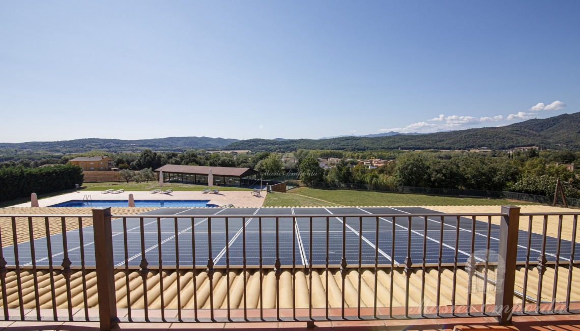 Terrassa d'una de les habitacions amb plaques solars a la coberta del porxo de la planta inferior