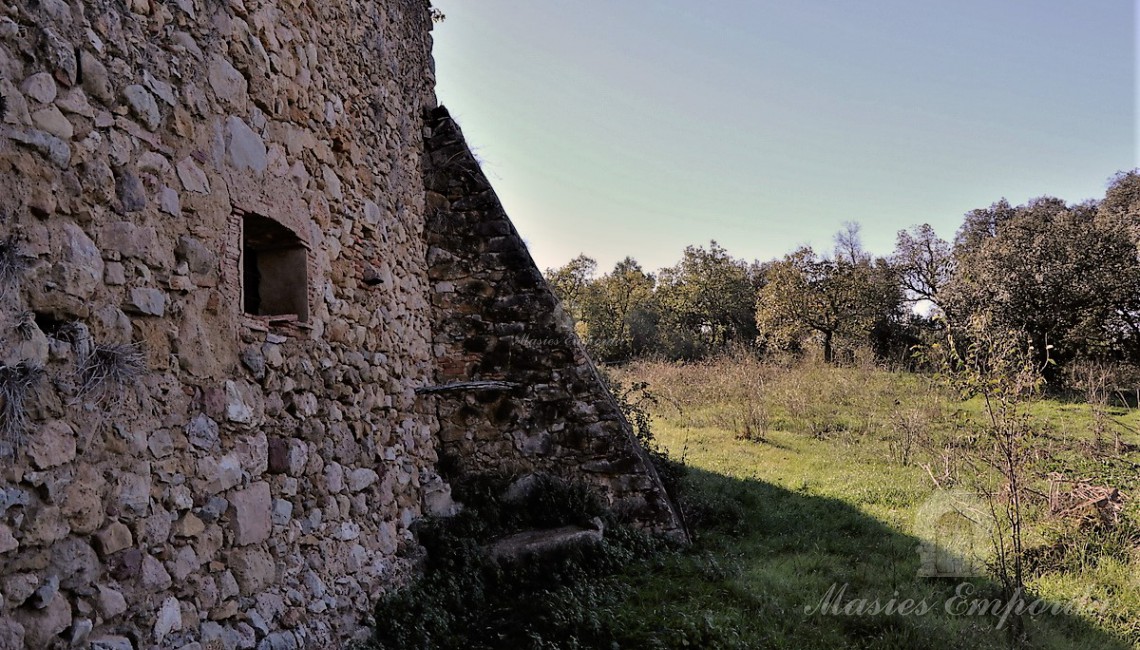 Vista des de l'interior del pati cap als camps de la casa