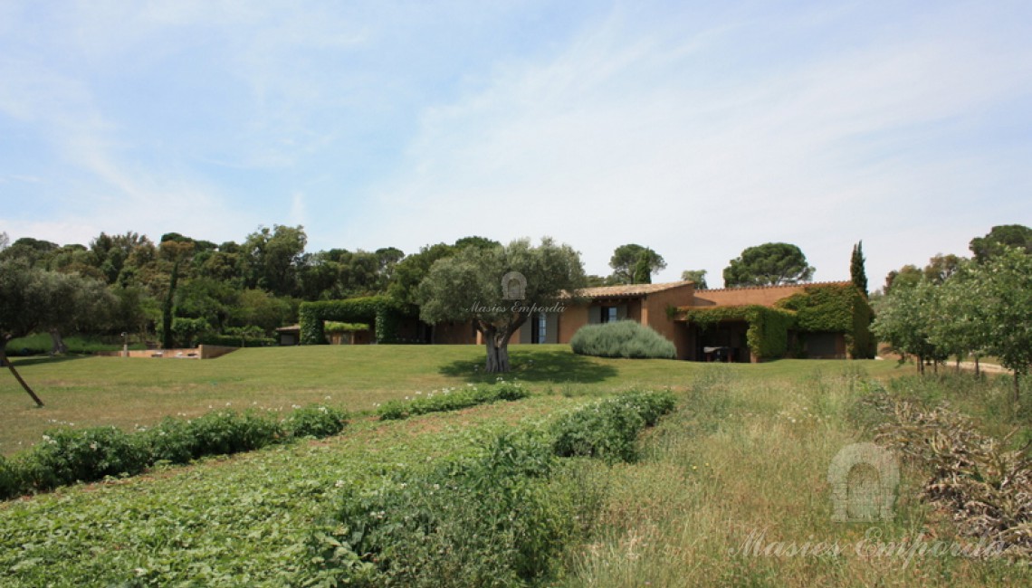 Vista de los campos y el jardín con la casa al fondo de la imagen