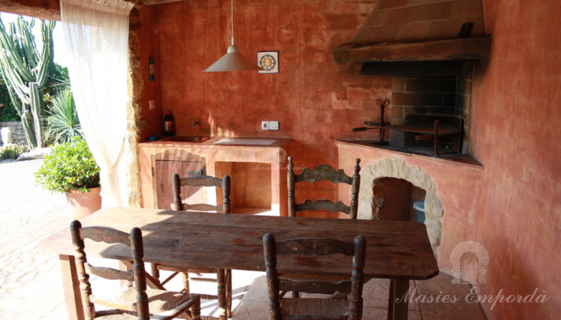 Comedor de verano y barbacoa junto a la piscina de la masía Comedor de verano y barbacoa junto a la piscina de la masía