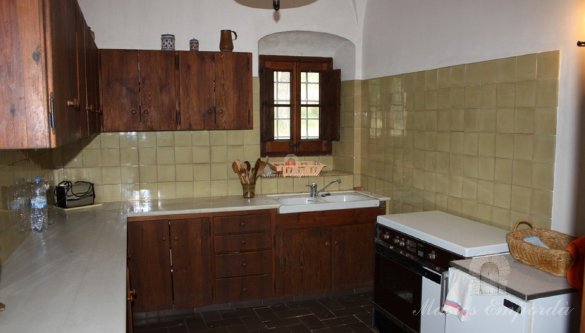 Cocina de la masía alicatada en verde claro ubicada en la segunda planta 