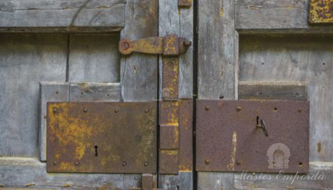 Detalle del segundo portón de madera y herrajes de forja de acceso al patio interior de la masía  