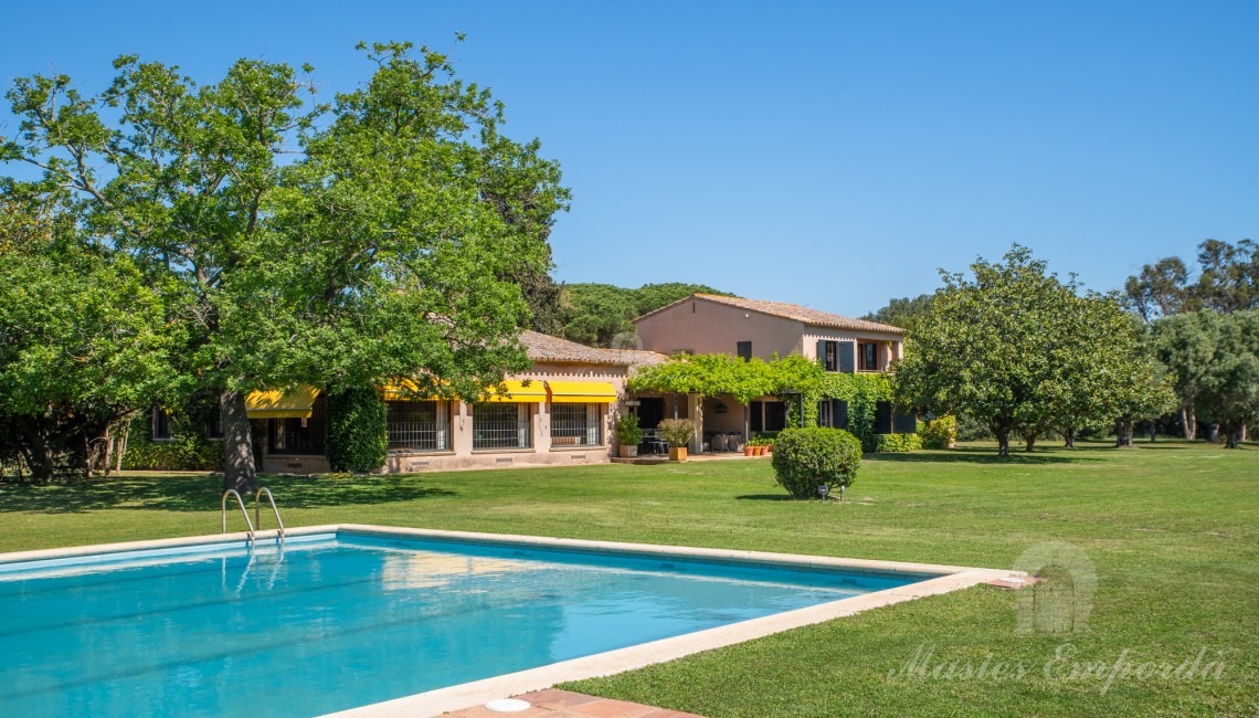 Vistes de la zona de piscina amb al pavelló al fons