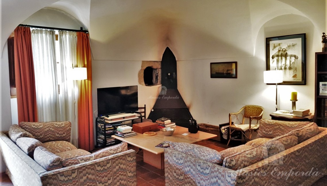Salón de estar de la casa con salida al jardín y la piscina 