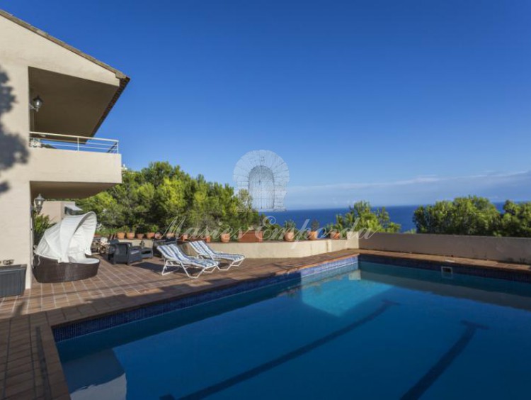 Vistas desde la piscina de parte de la casa, terraza solárium y el mar al fondo de la imagen. 