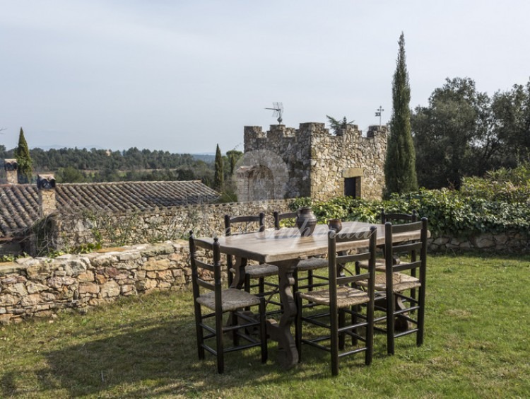 Zona de piscina con vistas a la torre de la masía y los campos y bosque de la propiedad