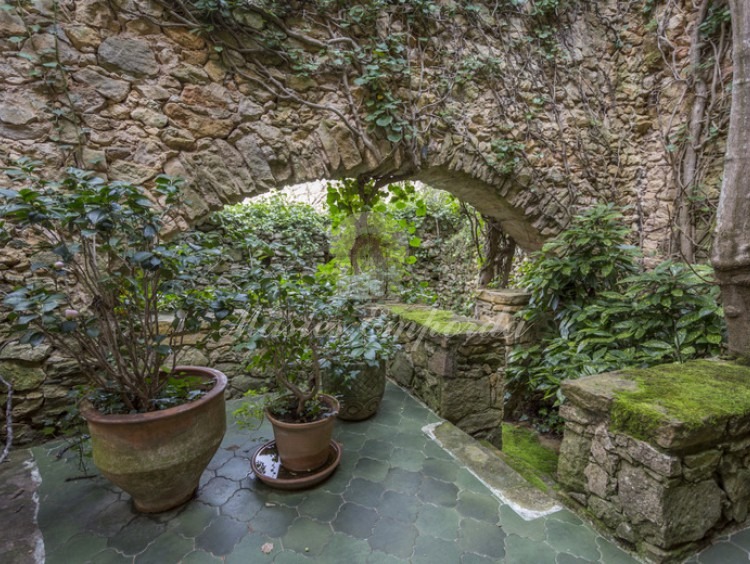 Detalle de la planta baja de la masía con el patio interior con arco de medio punto de piedra
