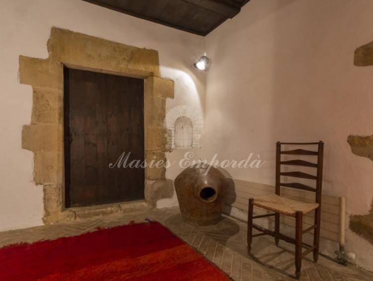  Detalle del hall de entrada a la masía con entrada a la bodega con dintel pilares en piedra trabajada
