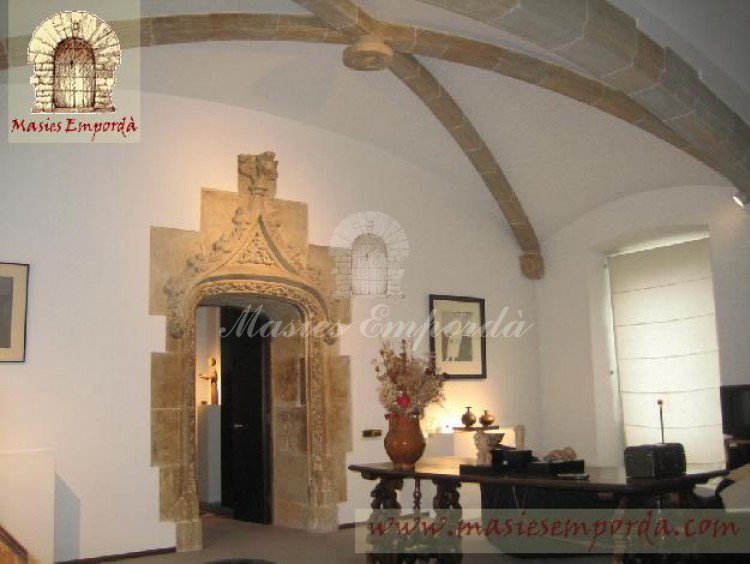 Salón del castillo abovedado con arco de medio punto de extremo a extremo de la sala con puerta con arco de piedra trabajada