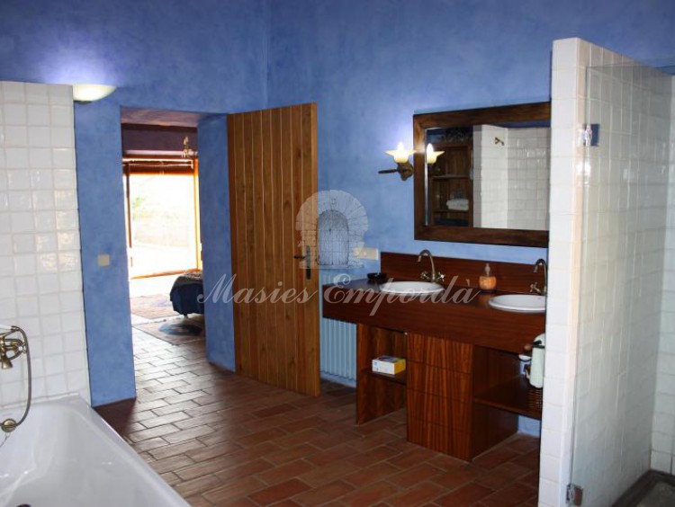 Vista desde el ángulo opuesto a la entrada del baño de la suite principal con bañera y ducha