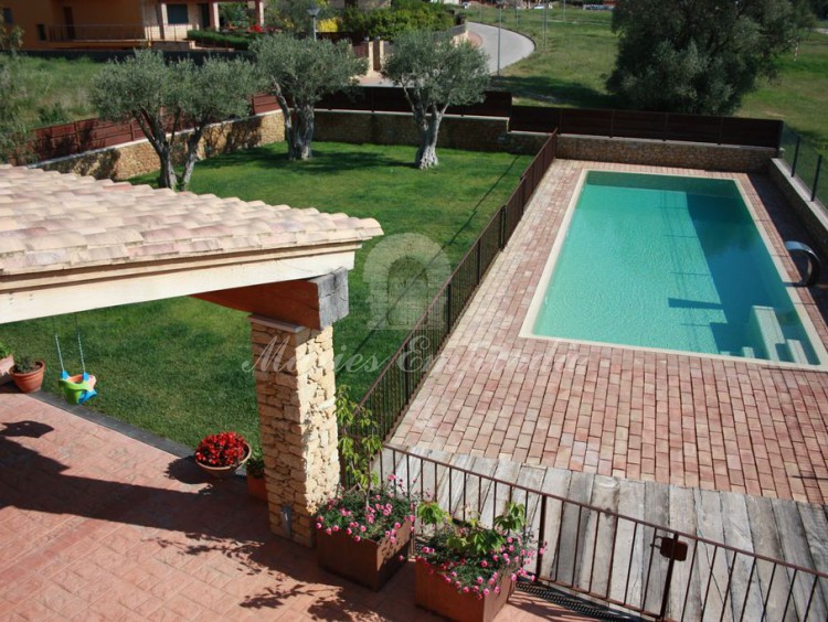 Vista de la piscina, jardín y porche dese la terraza de kla suite