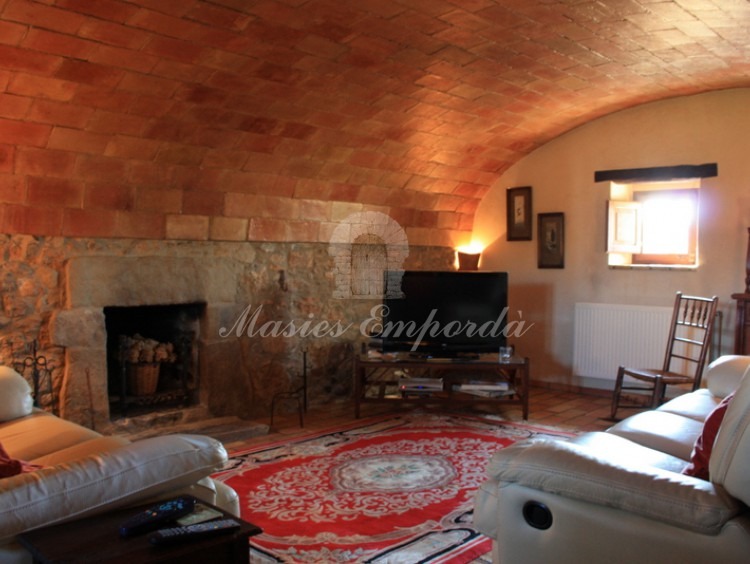 Salón de estar de la masía con chimenea con techos abovedaos Salón de estar de la masía con chimenea con techos abovedaos
