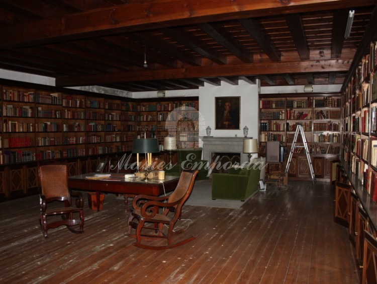 Biblioteca de la casa con techo con un artesonado de madera noble y chimenea 