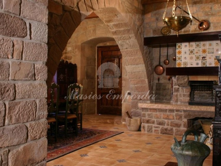 Detalle del asador de la cocina donde se aprecia un arco en piedra que recorre toda la estancia 