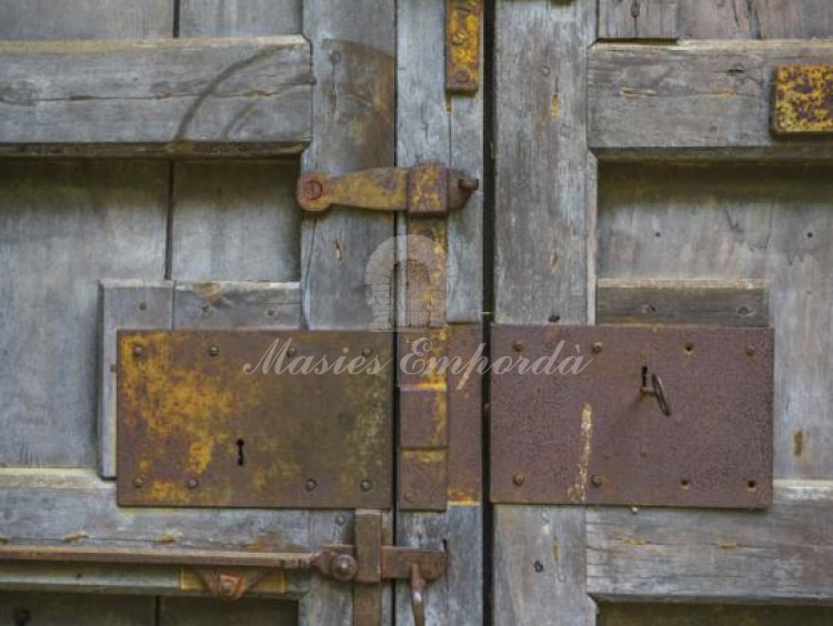 Detalle del segundo portón de madera y herrajes de forja de acceso al patio interior de la masía  