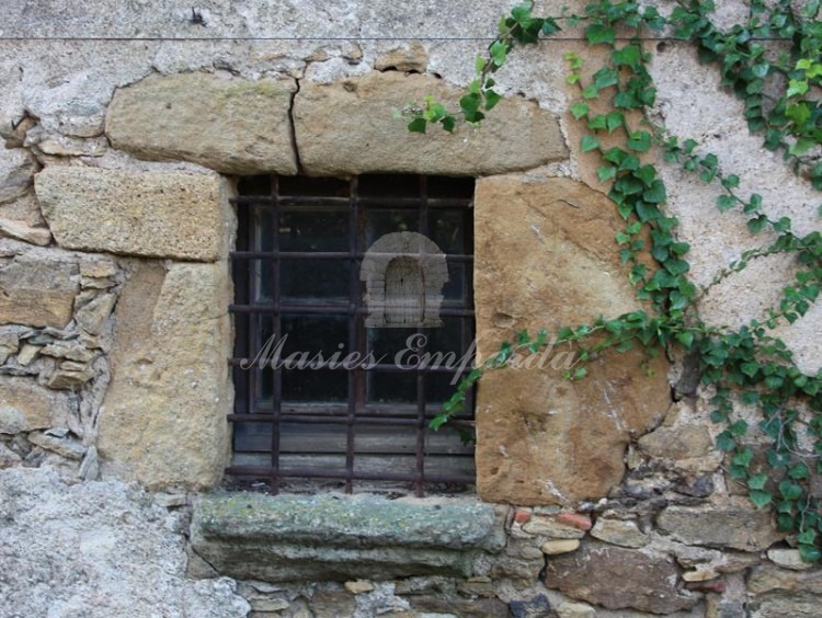 Detalle de una de las ventanas con dintel de piedra y pilares en piedra 