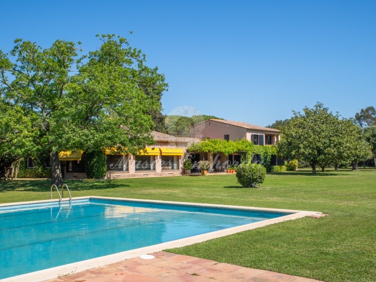 Vistes de la zona de piscina amb al pavelló al fons
